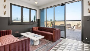 Ein modernes Interieur mit einer Couch, einem Couchtisch und einem gemusterten Teppich.