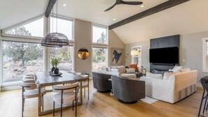 A spacious living area with a dining table, sofas, and a TV. - The Gem Estate by Avantstay Modern Farmhouse w/ Lavender Fields + Hot Tub (Bend)