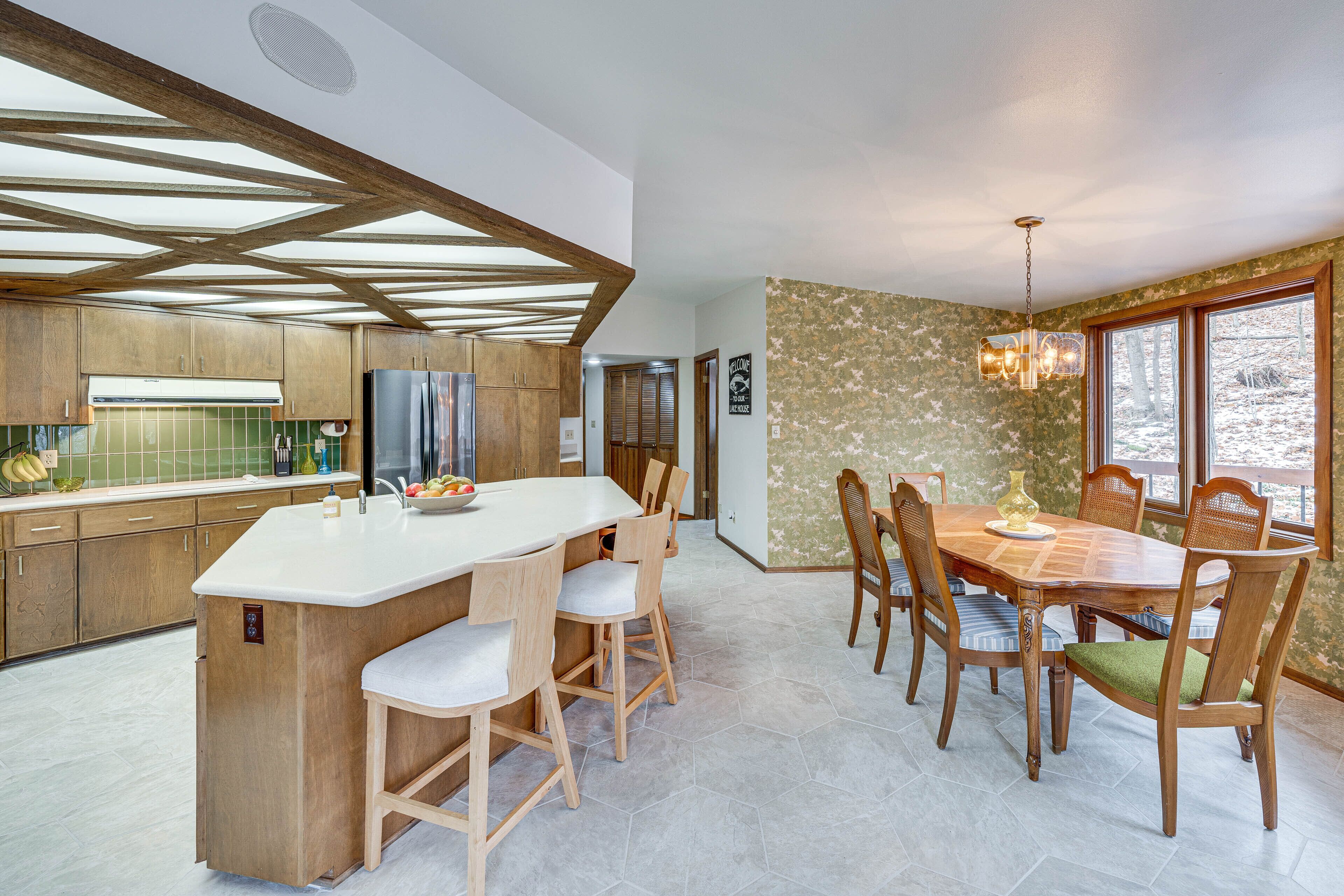 Eine moderne Küche mit Holzschränken, einer großen Kochinsel und einem Essbereich mit Holztisch und Stühlen.
