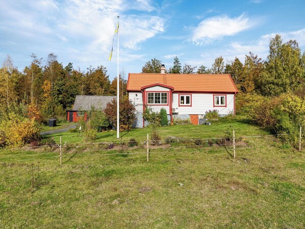 A house with a red-tiled roof, a flagpole, and a garden. - Skjutsmåla by Interhome (Olofström)