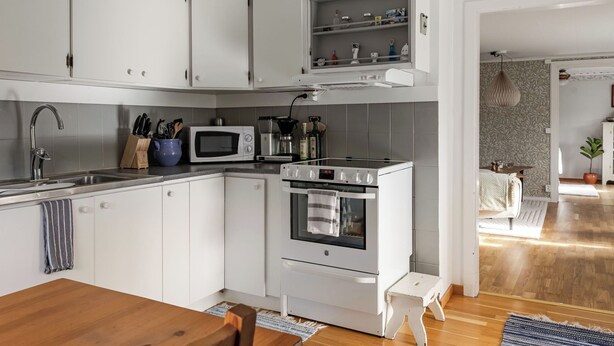 A modern kitchen with white cabinets, a microwave, an oven, and a coffee maker. - Skjutsmåla by Interhome (Olofström)