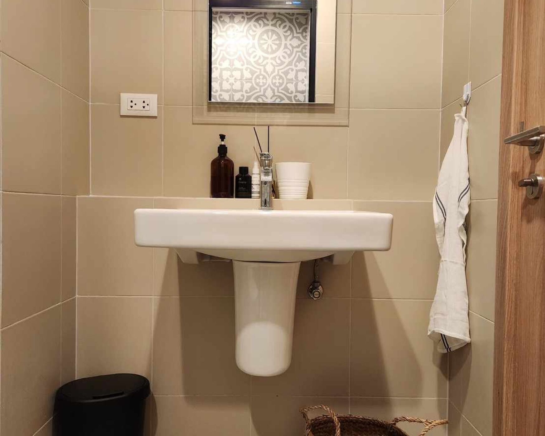 A bathroom with a white sink, a mirror, and a towel rack.