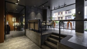 Un interior moderno con una escalera, una zona de estar y vistas al exterior.