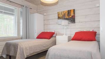 Un dormitorio con dos camas, una mesita de noche, una lámpara y un cuadro en la pared.
