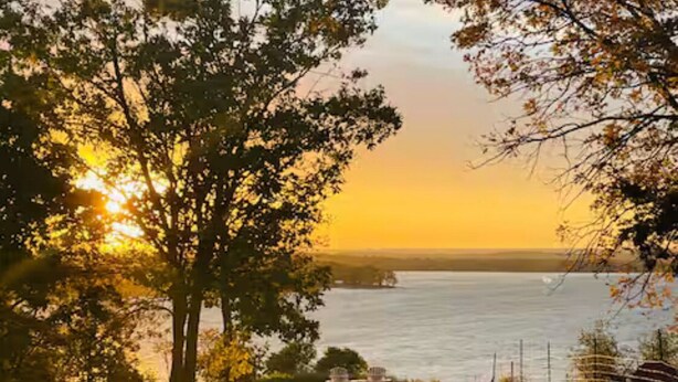A lakeside view with a sunset, trees, and two chairs on the grass. - Delightful 2bdrm Church w/Incredible Water View!

 (Prince Edward)