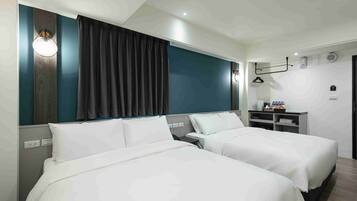 A hotel room with two beds, a desk, a chair, a wardrobe, and a hanging light fixture.