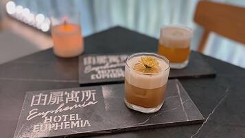 Two glasses of cocktails on a table with a menu.