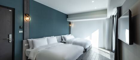 A modern hotel room with two beds, a large mirror, and a TV.