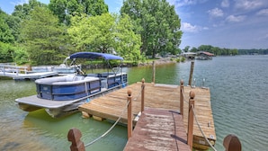 A wooden dock with a boat docked at the end. - Stay Awhile by AvantStay | Lakefront + Pool, Dock (Mooresville)