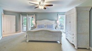 A bedroom with a bed, a ceiling fan, a wardrobe, and a view of the outdoors. - Lakefront w/ Private Dock + Hot Tub | Pontoon Rental | Butler Bliss by AvantStay (Sherrills Ford)