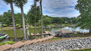 A lakeside dock with boats, a gazebo, and a rocky shoreline. - Shades of Summer by AvantStay | Gazebo, Dock, View (Denver)