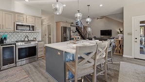 A kitchen with stainless steel appliances, a central island, and pendant lighting. - Lakefront Estate | Pool + Hot Tub + Dock + Sauna | Oasis at Ballycastle (Mooresville)