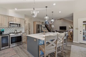 A kitchen with stainless steel appliances, a central island, and pendant lighting.