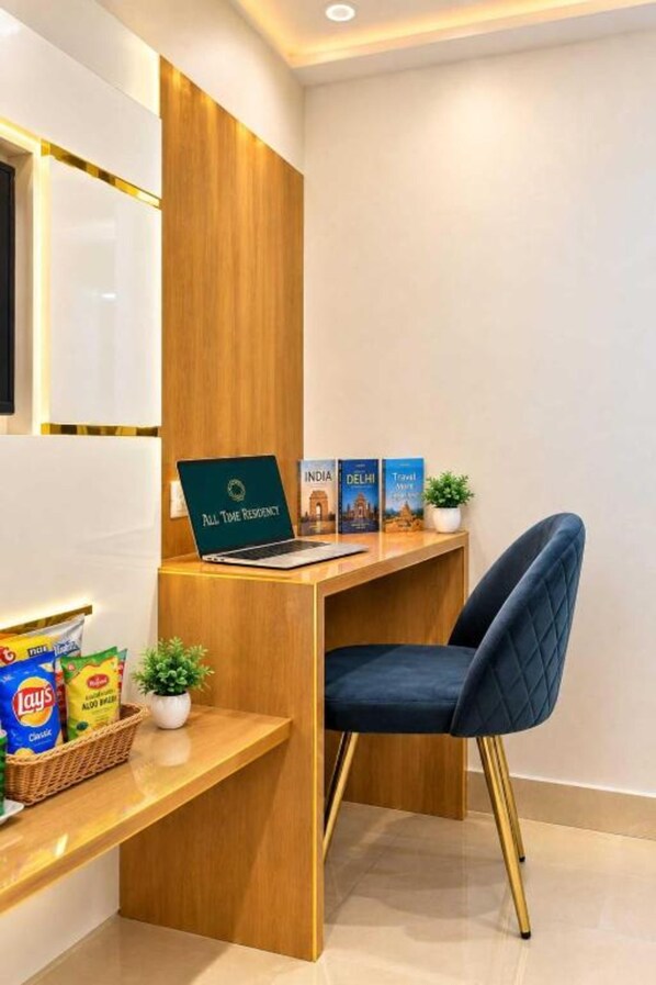 Un mostrador de recepción con una computadora portátil, una zona de estar y folletos turísticos.