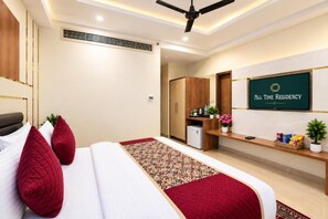 A hotel room with a bed, a desk, a refrigerator, and a television displaying 'All Time Residency'. - Hotel All Time Residency - Near Connaught Place New Delhi (New Delhi)