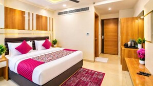 A hotel room with a bed, bedside table, nightstand, and a desk with a chair. - Hotel All Time Residency - Near Connaught Place New Delhi (New Delhi)