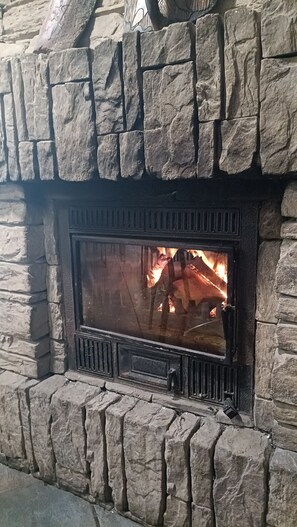 Ein Kamin aus Stein mit brennendem Feuer.