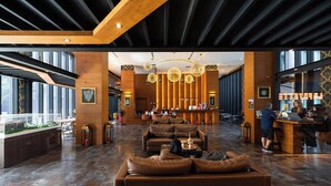 Un hall d’entrée spacieux, doté de canapés en cuir, d’un comptoir de réception et d’une grande fenêtre offrant une vue panoramique.