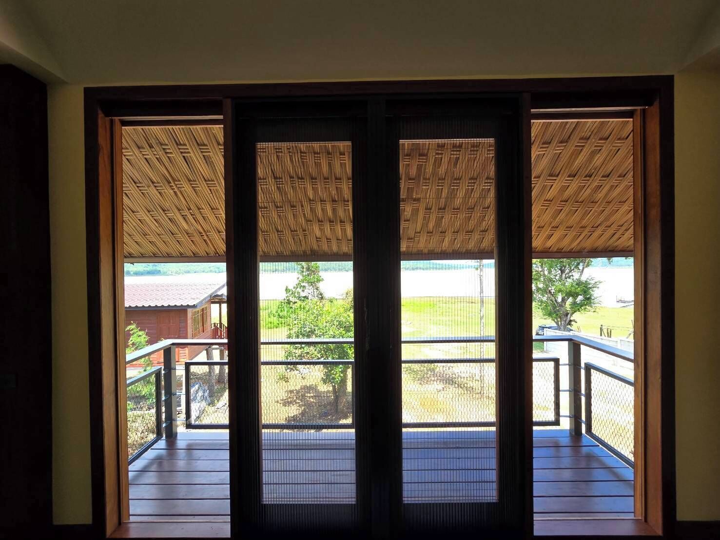 A room with a large sliding door leading to an outdoor balcony with a wooden ceiling.