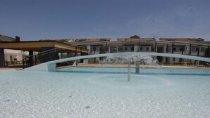 Une piscine avec une fontaine, entourée d’immeubles dotés de balcons.