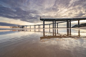 A pier extending into calm waters with a cloudy sky above. - Ferienwohnung Strandbrise (Koserow)