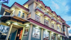 A multi-story hotel with a modern architectural design, featuring balconies and large windows. - Essence Hotel (Ndenderu)