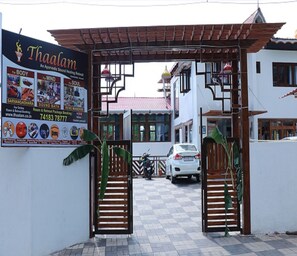 A gated entrance to a building with a signboard advertising sound healing services. - Thaalam-an ayurvedic Resort (Yercaud)