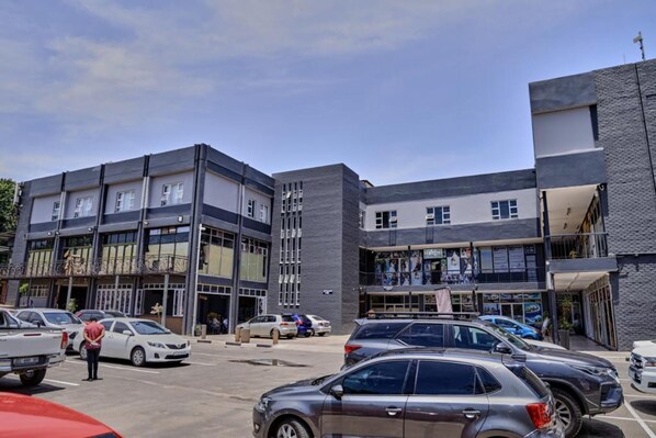 A multi-story building with a modern architectural design, featuring large windows and a mix of glass and concrete facades.