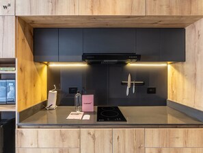 Een koelkast, een kookplaat, kookgerei, borden en bestek