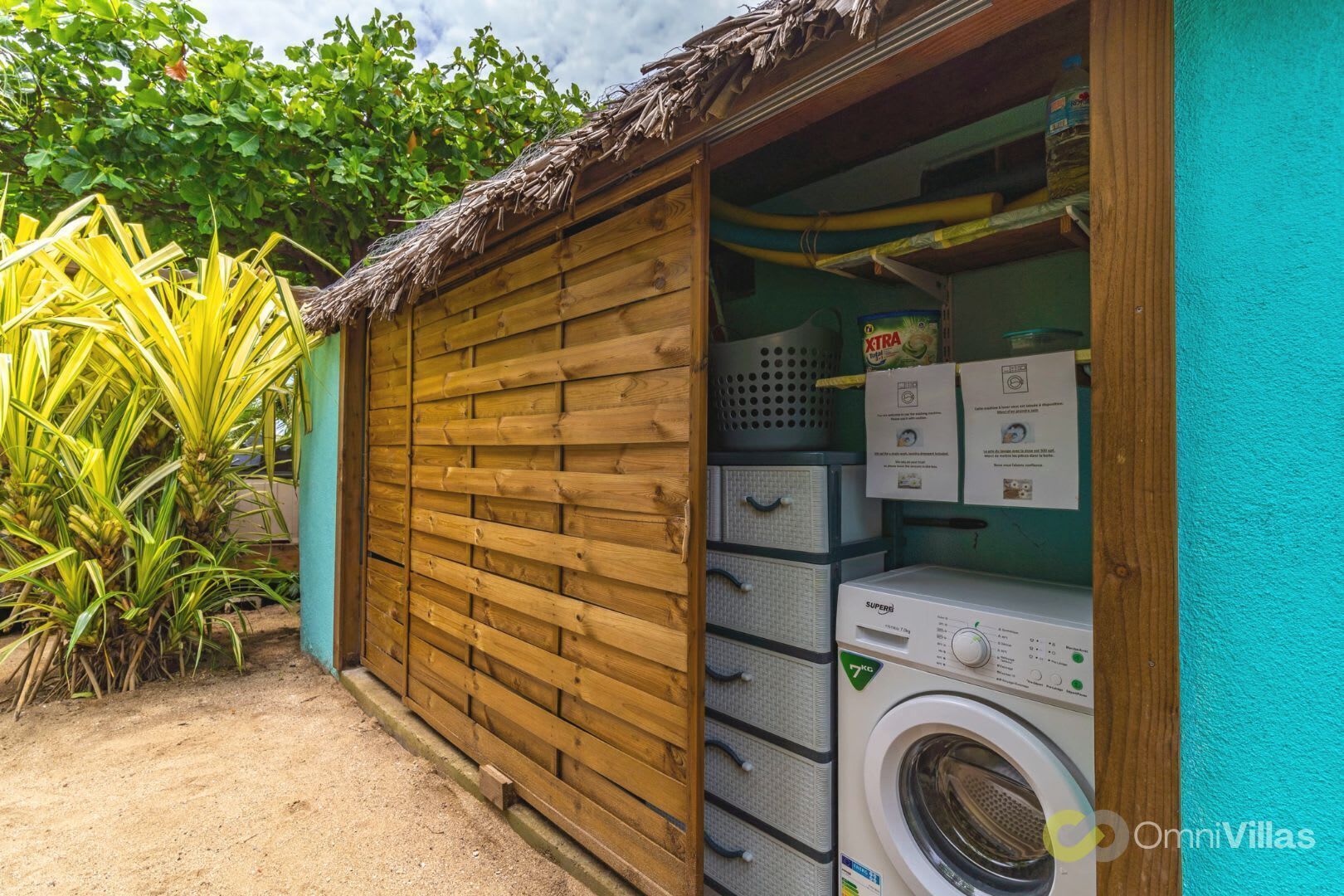 A laundry room with a wooden wall and a washing machine.