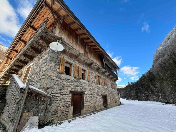 Un edificio in pietra con balconi in legno e un'antenna parabolica.