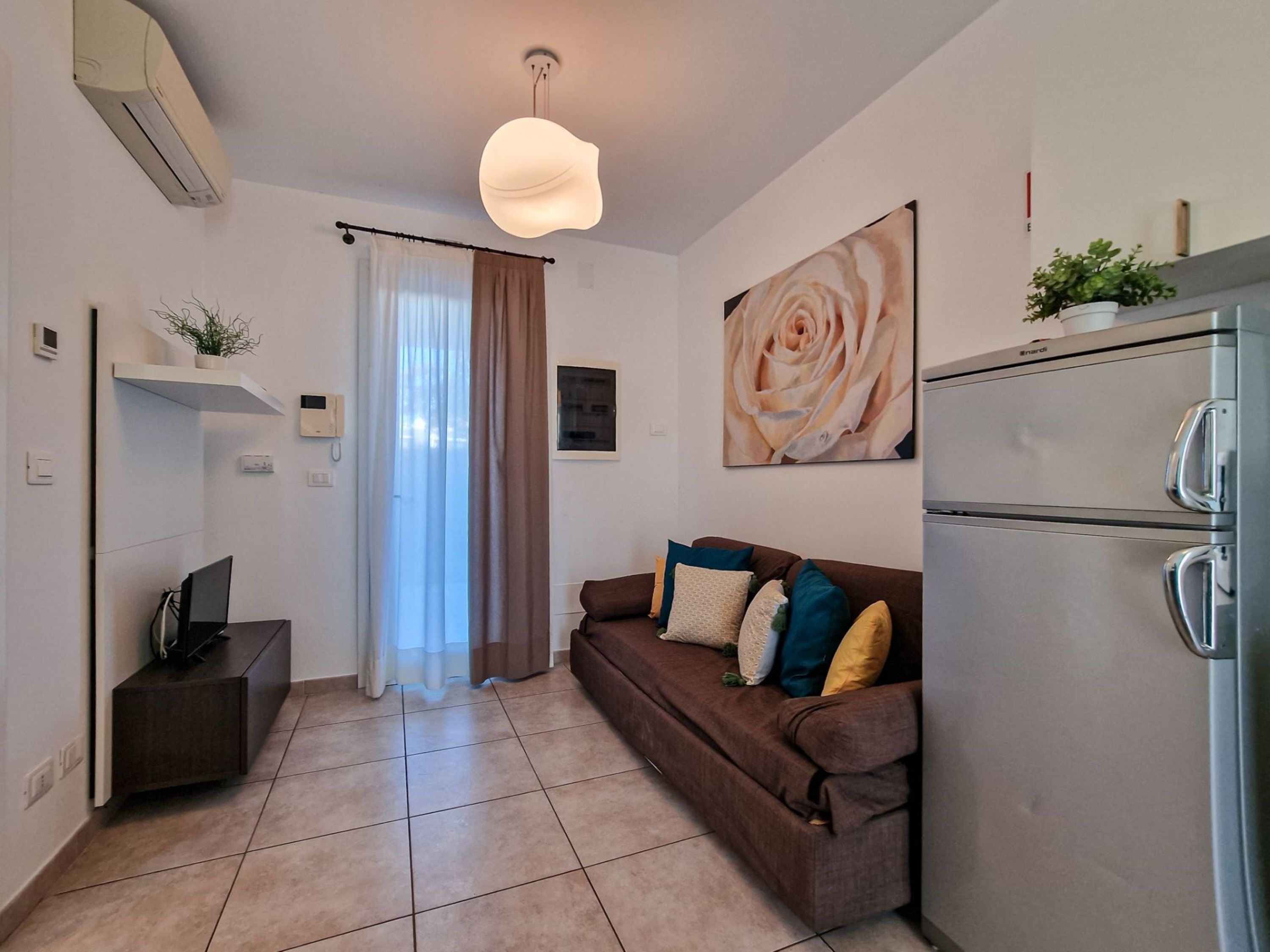 A compact living space with a sofa, a dining area, and a kitchen.