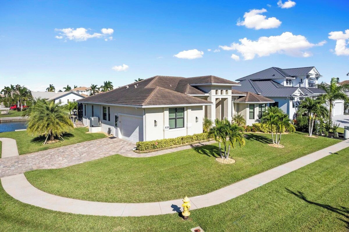 A residential house with a garage, a well-maintained lawn, and a fire hydrant.