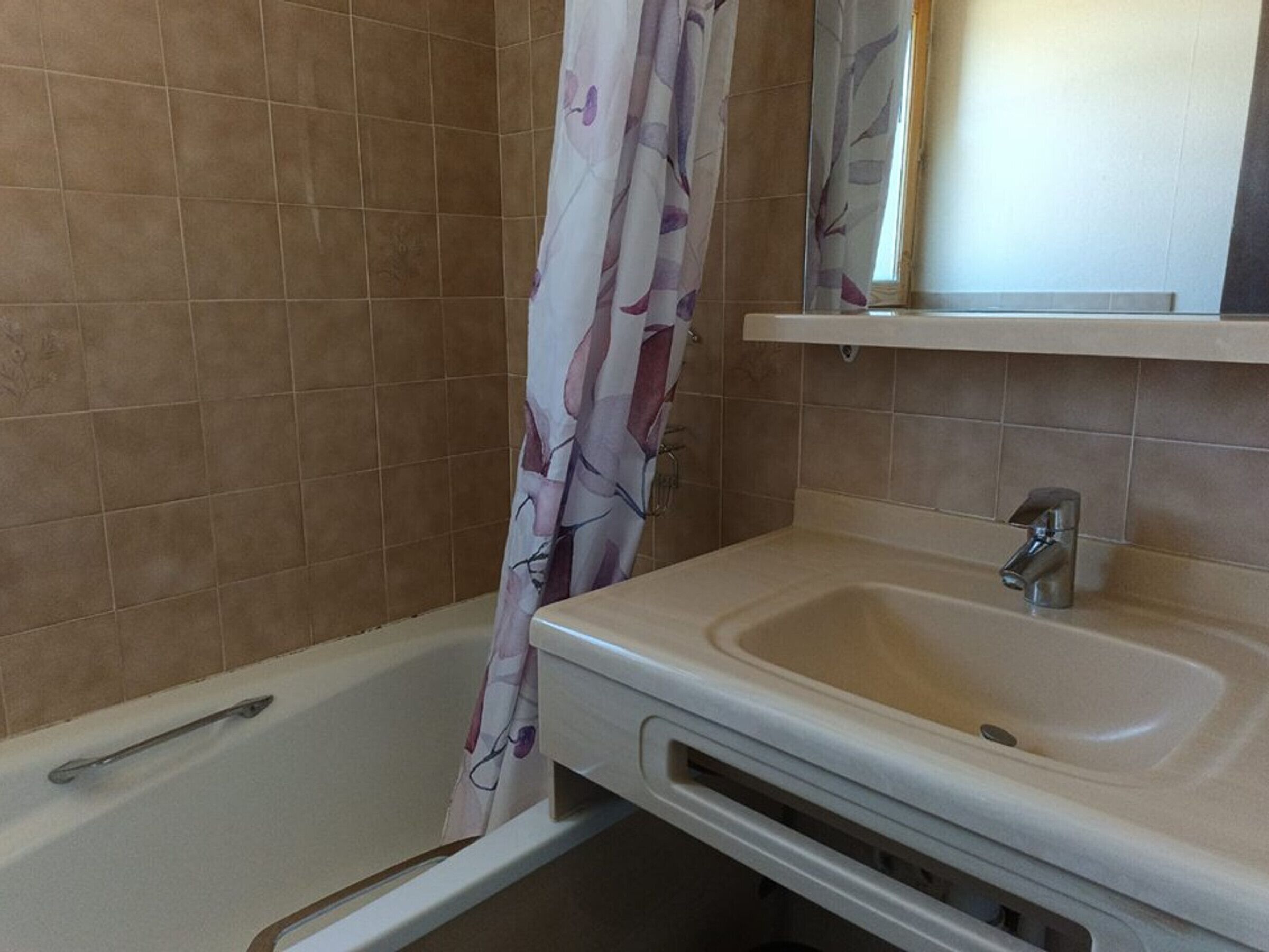 Ein Badezimmer mit Badewanne, Waschbecken und Spiegel.