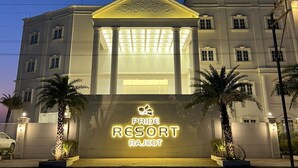 L’entrée d’un hôtel, avec une enseigne indiquant : « PRIDE RESORT RAJKOT ».