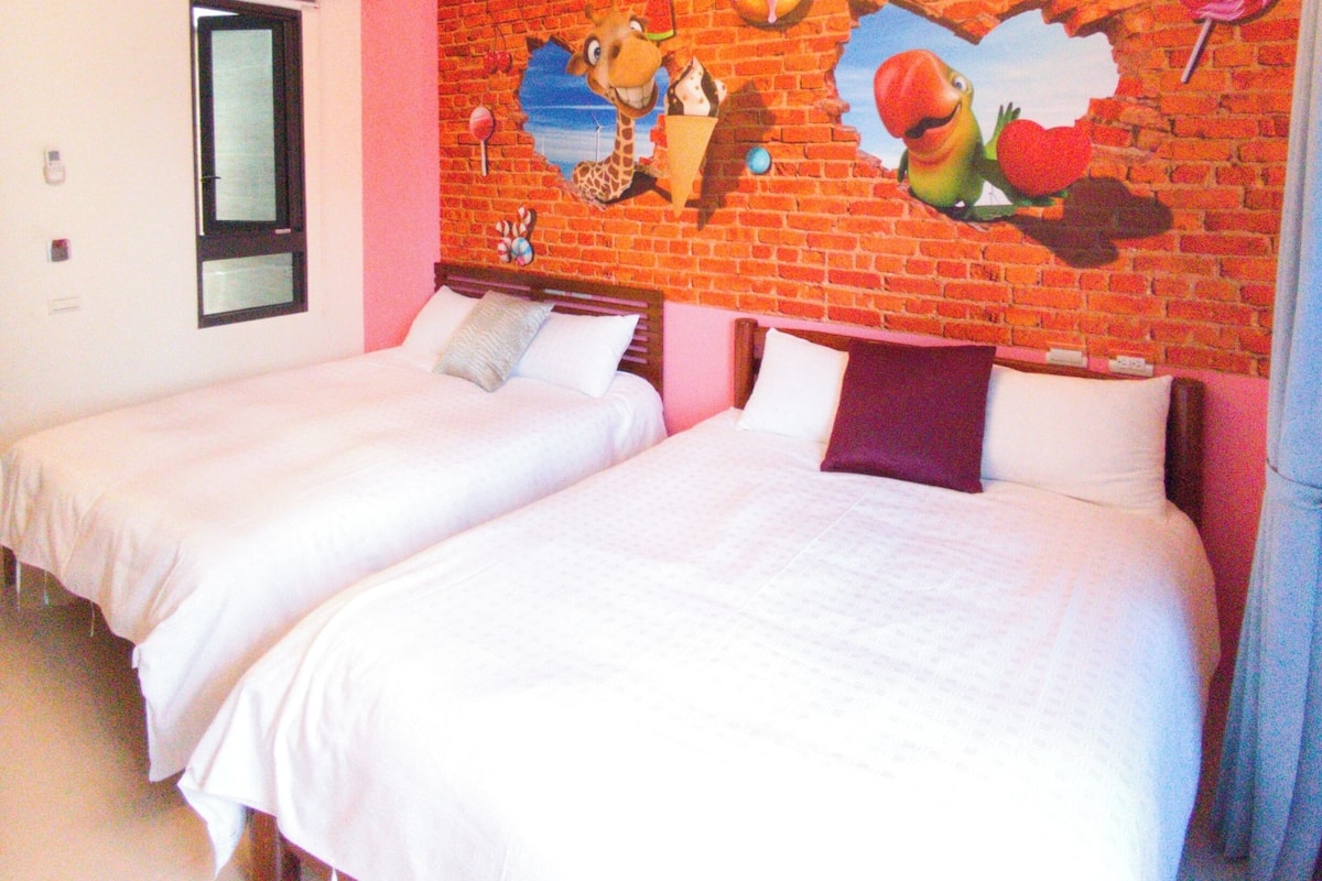 A hotel room with two beds, a brick wall mural, and a ceiling light fixture.