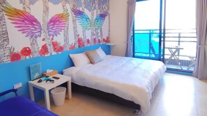 Une chambre avec un lit, un bureau, une chaise et un balcon offrant une vue.