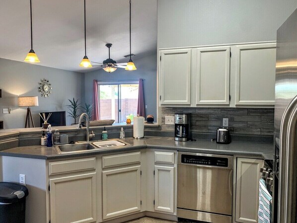 A modern kitchen with a dishwasher, coffee maker, and a built-in oven.
