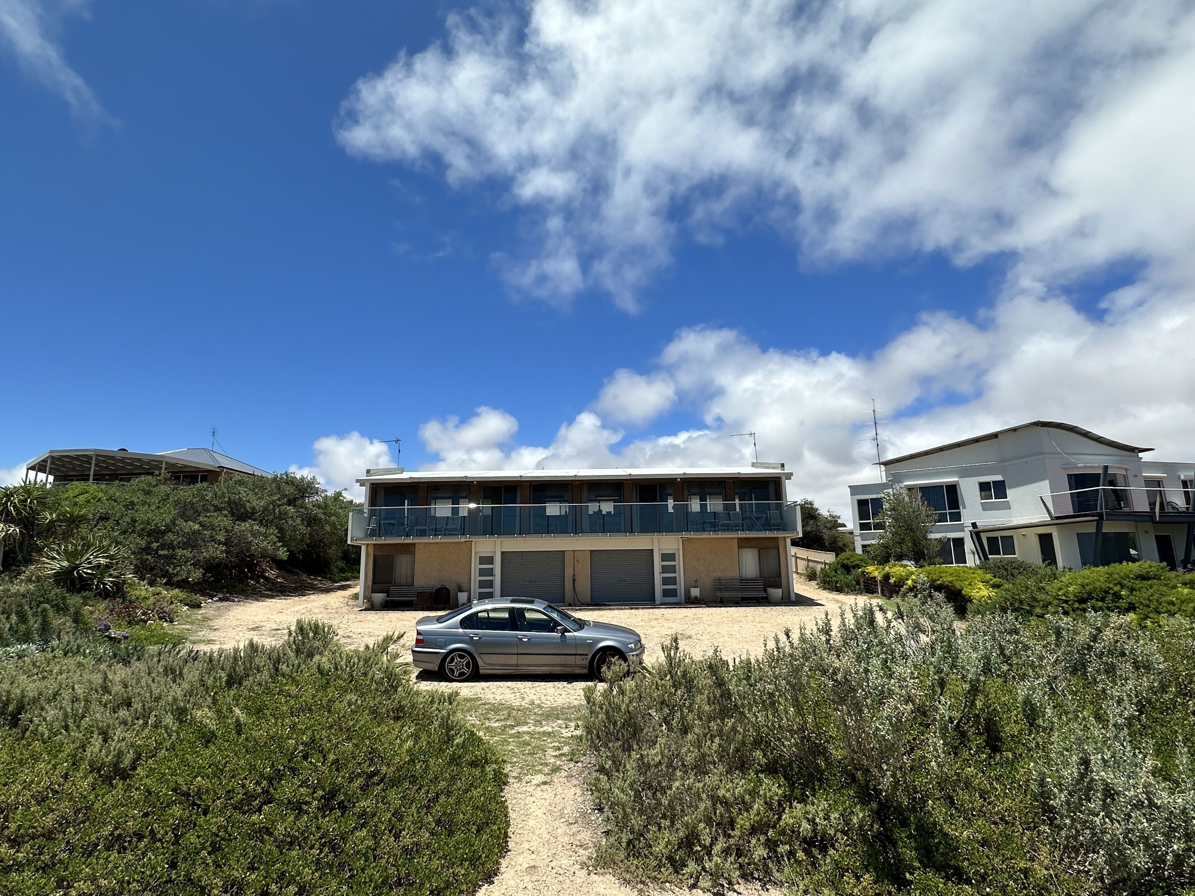 A modern two-story house with a car parked in front.