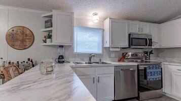 Kitchen: The white cabinetry offers ample storage, and the kitchen island is perfect for a quick snack or a morning cup of coffee.