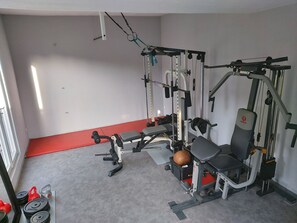 A gym with various exercise equipment, including a bench, weight racks, and a power rack.