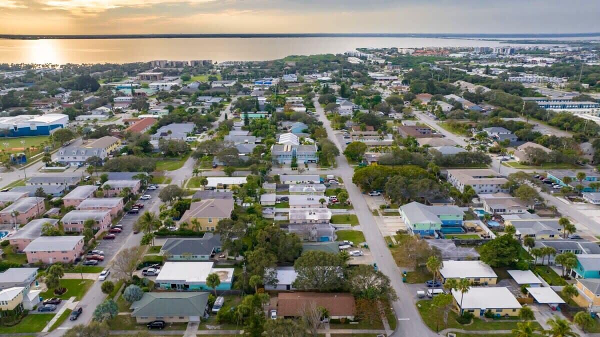 Una zona residencial con casas, calles y una masa de agua al fondo.