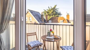 A balcony with a table, chairs, and a view of houses and trees. - Windsor Gem:3 Bed|2 Bath|Parking - By Tempstay (Windsor)