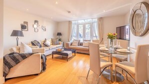 A modern living room with a sofa, coffee table, dining table, and chairs. - Windsor Gem:3 Bed|2 Bath|Parking - By Tempstay (Windsor)