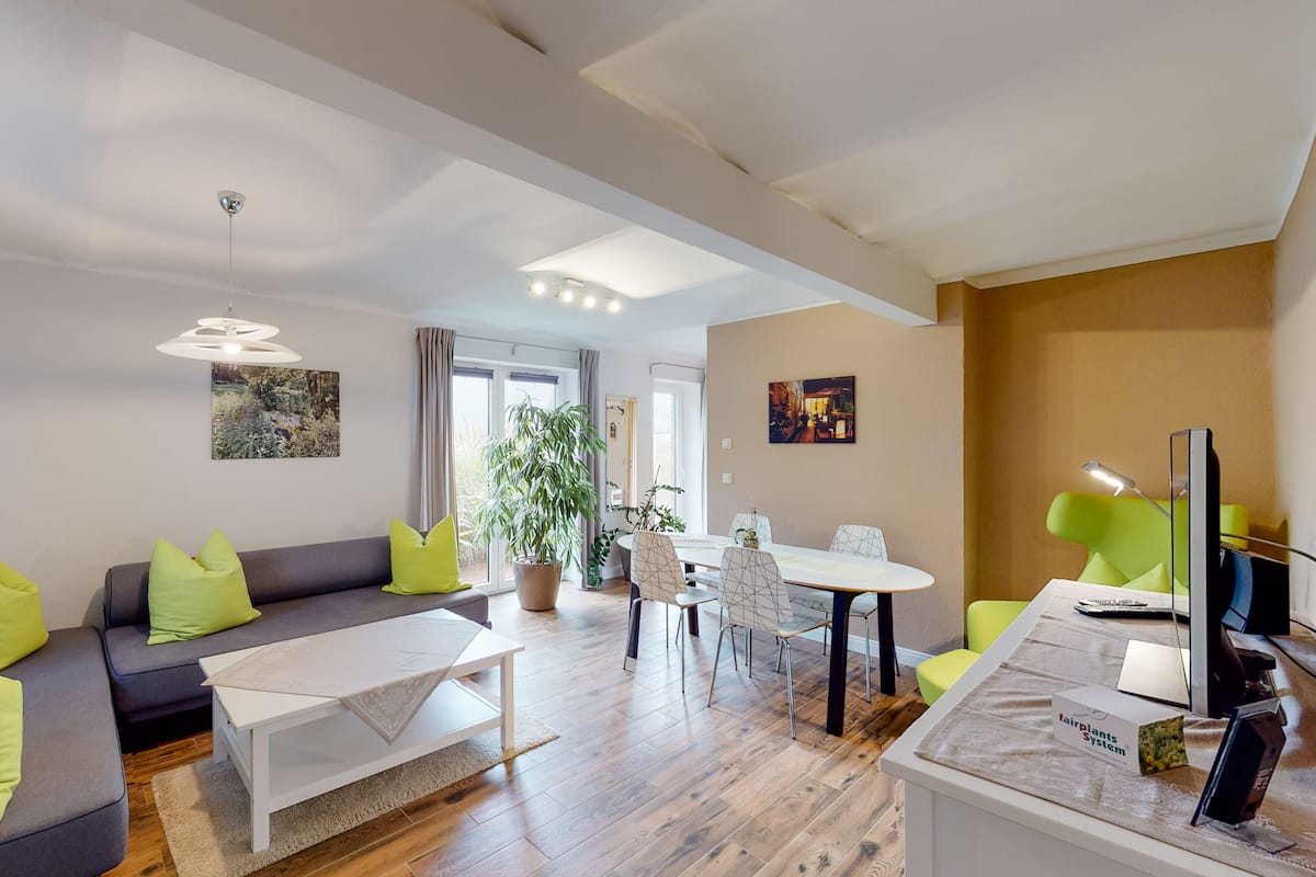 Ein modernes Wohnzimmer mit einer Couch, einem Couchtisch und einem Essbereich.