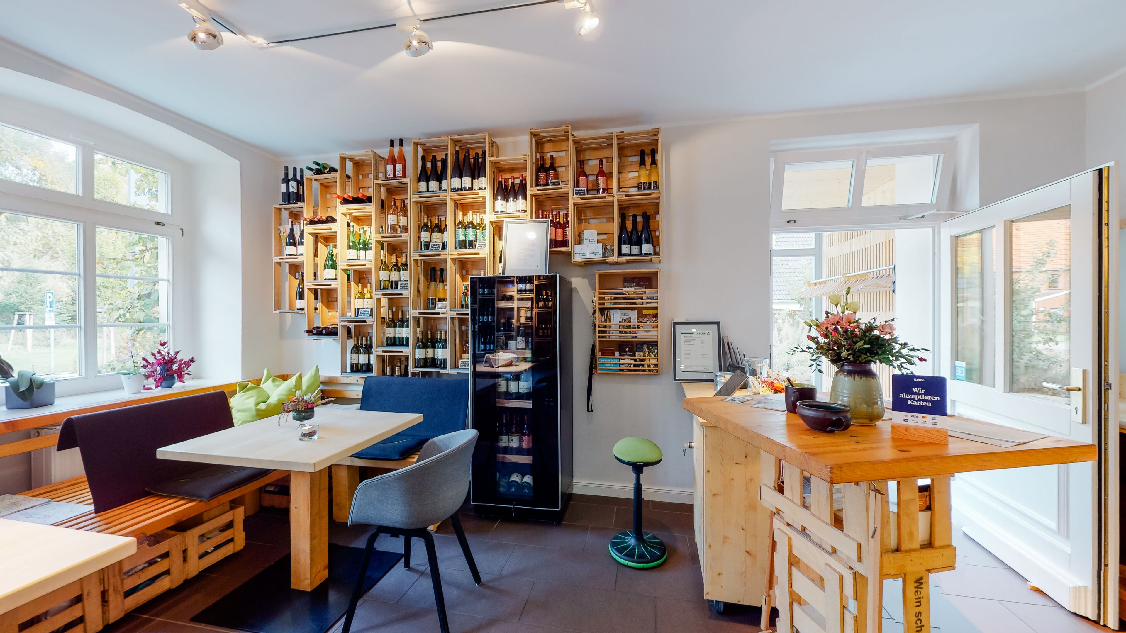 Eine moderne Küche mit Holzausstattung, einem Essbereich mit Tisch und Stühlen sowie einem Weinschrank, der mit Flaschen gefüllt ist.