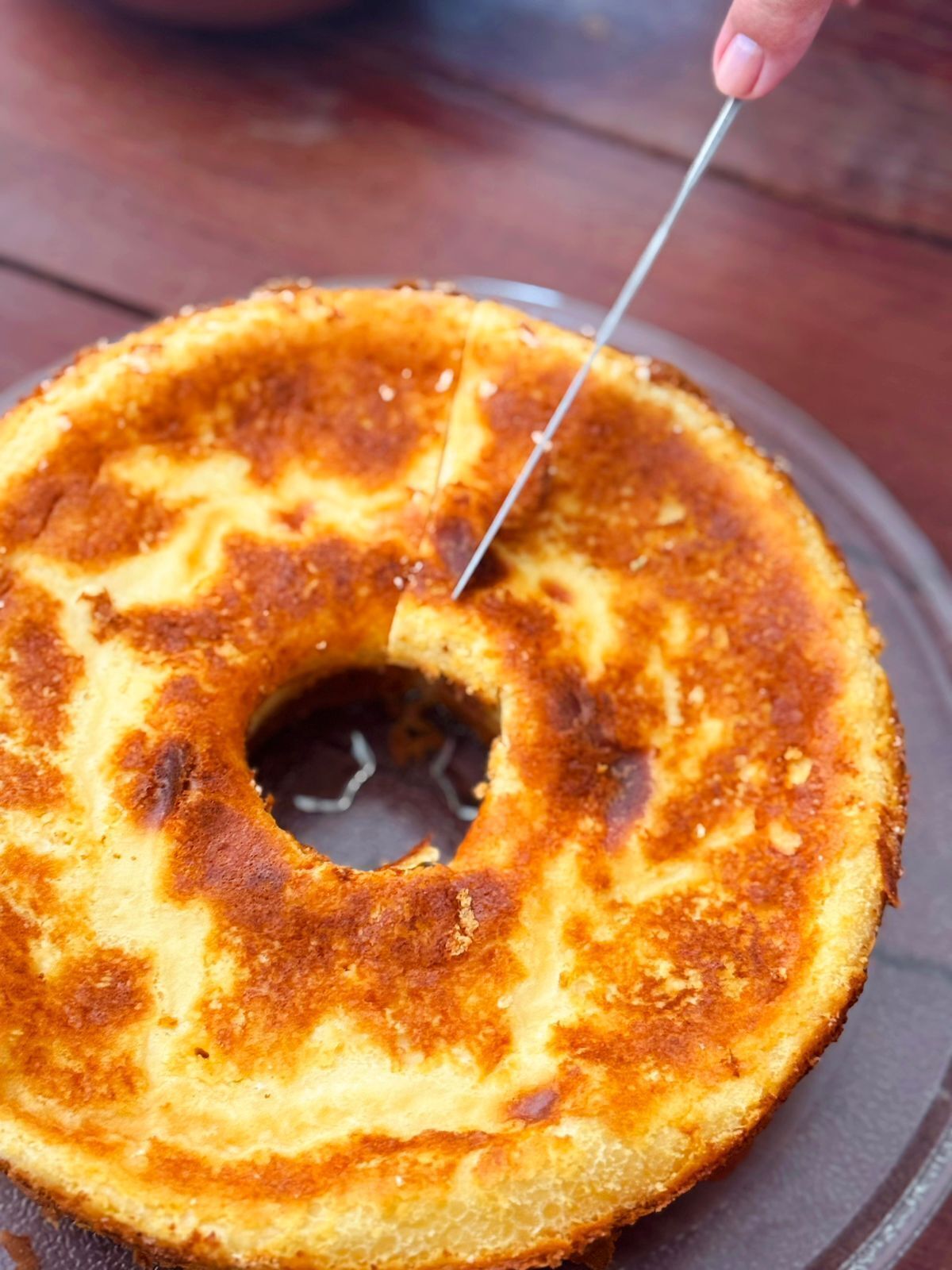 A cake with a hole in the center, possibly a bundt cake, on a plate.