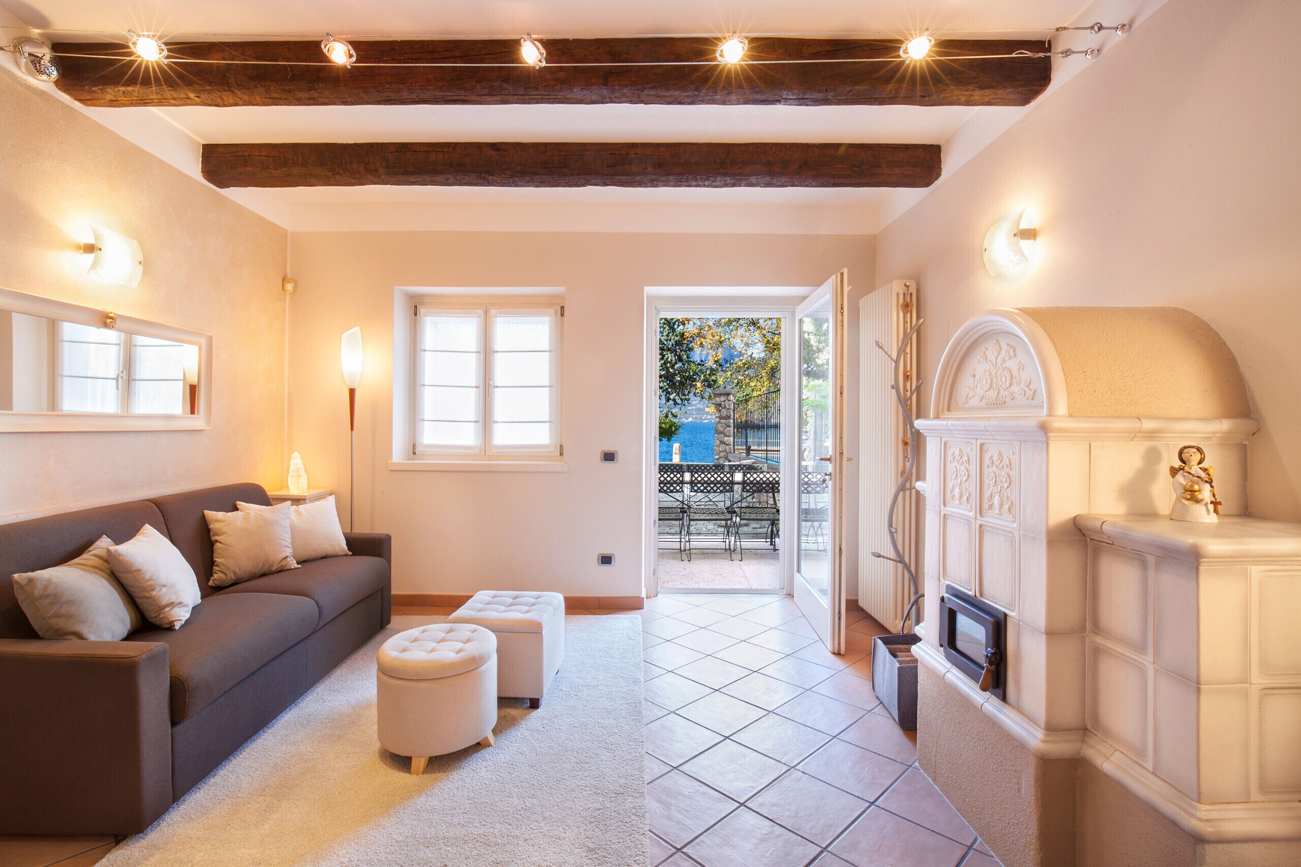 Un salon chaleureux avec un canapé, des poufs et une cheminée.