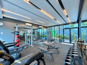 Una palestra moderna con diverse attrezzature per esercizi, ampie finestre e vista all'esterno.