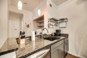 A modern kitchen with granite countertops, stainless steel appliances, and a built-in dishwasher. - I50 - Apt|Patio|11mi to Convention Ctr|Sleeps 2 (Irving)